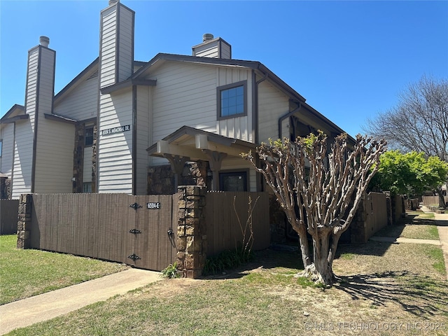 view of front of property featuring fence, a gate, and a chimney