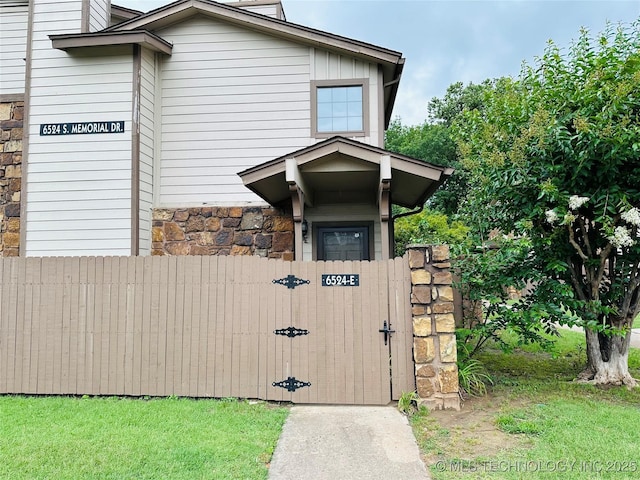 6524 S Memorial Dr Unit 16E, Tulsa, OK 74133 - doorway to property with stone siding and a gate
