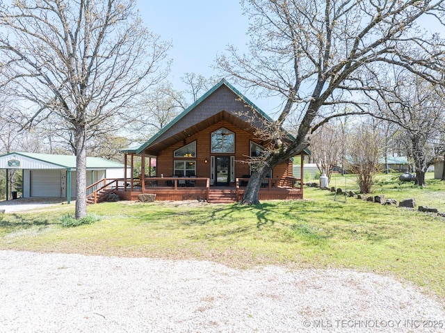 view of front facade featuring a detached garage, an outdoor structure, a carport, a front yard, and driveway