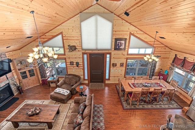 living area with wooden walls, a notable chandelier, wooden ceiling, and wood finished floors