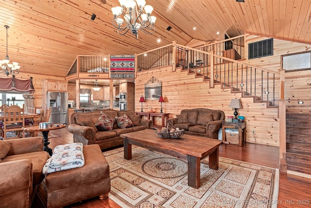 living area featuring stairs, wooden walls, wood ceiling, and an inviting chandelier