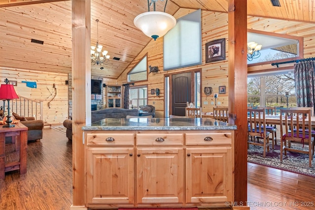 kitchen with wood walls, open floor plan, high vaulted ceiling, and an inviting chandelier