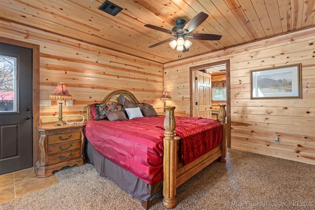 bedroom featuring wooden walls, visible vents, multiple windows, and wooden ceiling