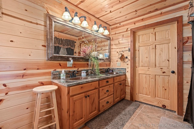 bathroom with a sink, double vanity, tile patterned flooring, wood walls, and wooden ceiling