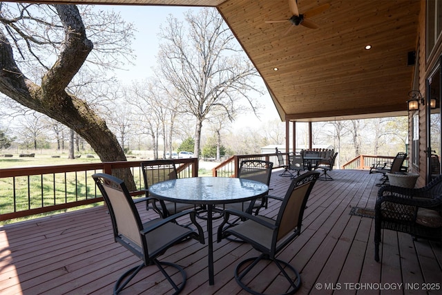 deck with outdoor dining space and ceiling fan