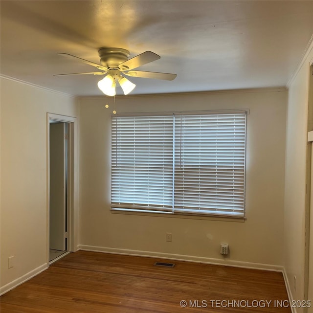 unfurnished room featuring crown molding, baseboards, a ceiling fan, and wood finished floors