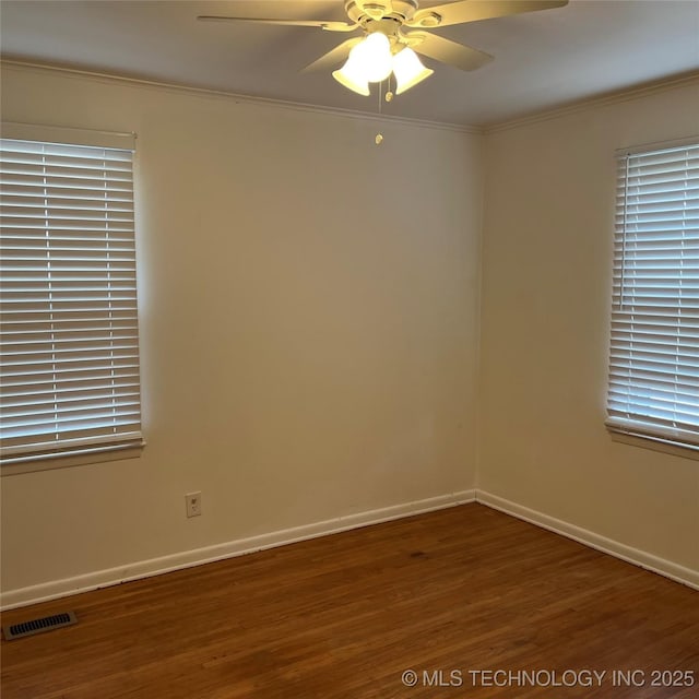 spare room featuring baseboards, a ceiling fan, crown molding, visible vents, and wood finished floors
