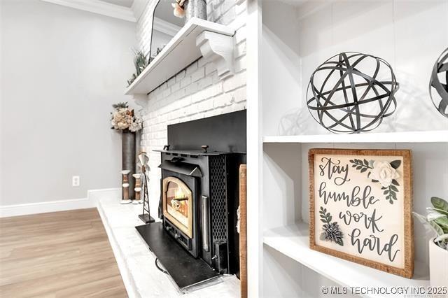 interior details with baseboards, crown molding, and wood finished floors