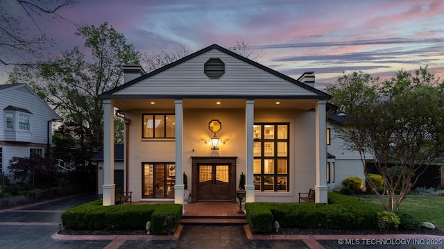 view of front of property featuring a chimney and covered porch