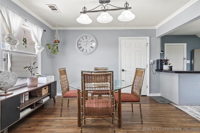 dining area with ornamental molding, visible vents, and wood finished floors