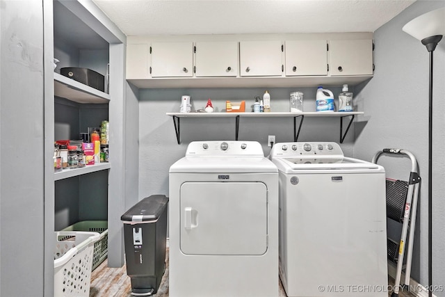 washroom with cabinet space, separate washer and dryer, and wood finished floors