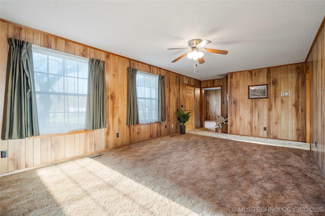 14531 S 107th W Ave, Sapulpa, OK 74066 - carpeted empty room with a textured ceiling, wooden walls, a ceiling fan, and visible vents