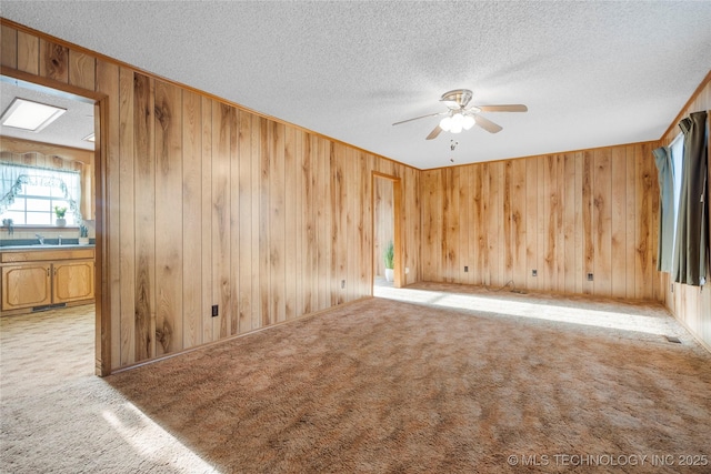 14531 S 107th W Ave, Sapulpa, OK 74066 - unfurnished room with wood walls, carpet flooring, a textured ceiling, and a ceiling fan