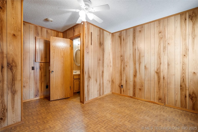 14531 S 107th W Ave, Sapulpa, OK 74066 - spare room featuring wooden walls, baseboards, ceiling fan, and a textured ceiling