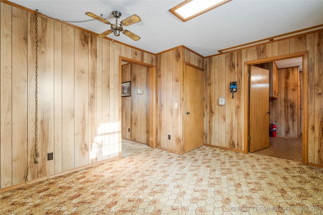 14531 S 107th W Ave, Sapulpa, OK 74066 - empty room featuring baseboards, a ceiling fan, a textured ceiling, crown molding, and wooden walls