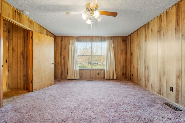 14531 S 107th W Ave, Sapulpa, OK 74066 - unfurnished room with a textured ceiling, a ceiling fan, wood walls, visible vents, and carpet
