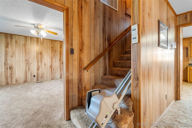 14531 S 107th W Ave, Sapulpa, OK 74066 - staircase featuring a textured ceiling, wooden walls, a ceiling fan, and carpet