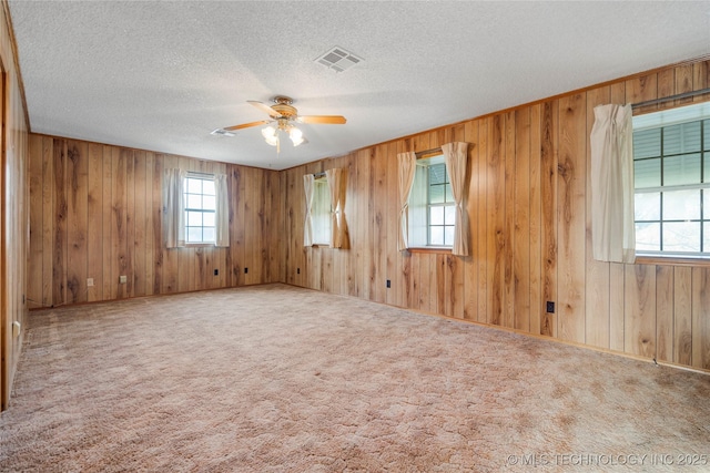 14531 S 107th W Ave, Sapulpa, OK 74066 - carpeted spare room featuring wood walls, visible vents, a textured ceiling, and a ceiling fan