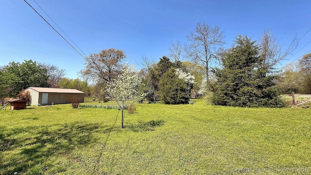 view of green lawn with an outdoor structure and an outbuilding