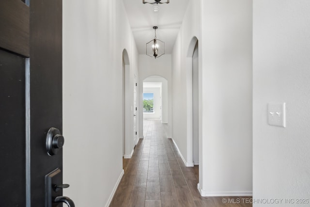 2916 S 8th St, Broken Arrow, OK 74012 - hall featuring arched walkways, dark wood-style floors, and a chandelier