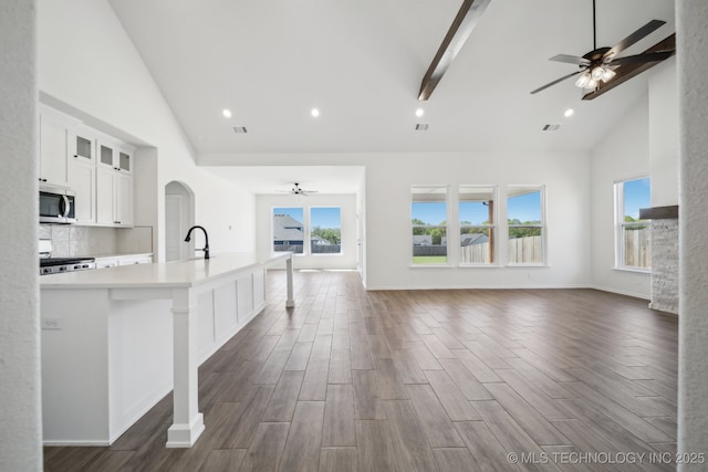 2916 S 8th St, Broken Arrow, OK 74012 - kitchen with stove, stainless steel microwave, open floor plan, high vaulted ceiling, and ceiling fan