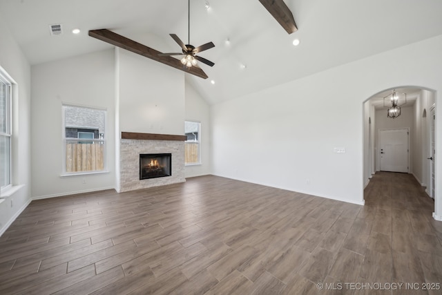 2916 S 8th St, Broken Arrow, OK 74012 - unfurnished living room featuring arched walkways, high vaulted ceiling, a ceiling fan, beam ceiling, and dark wood-style flooring