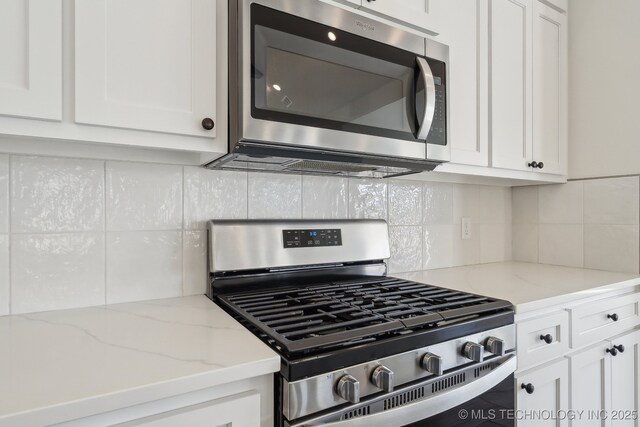 2916 S 8th St, Broken Arrow, OK 74012 - kitchen featuring stainless steel appliances, white cabinets, tasteful backsplash, and light stone countertops