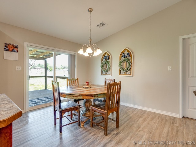 dining space with visible vents, baseboards, a notable chandelier, and light wood-style floors