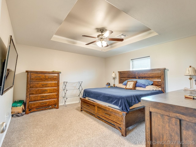 bedroom with visible vents, a raised ceiling, ceiling fan, crown molding, and carpet flooring