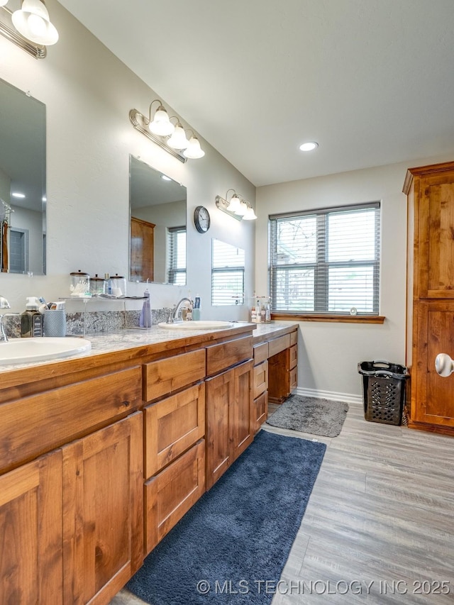 bathroom with double vanity, a sink, and a healthy amount of sunlight