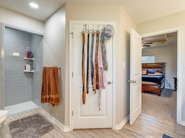 bathroom with tiled shower, ensuite bath, baseboards, and wood finished floors