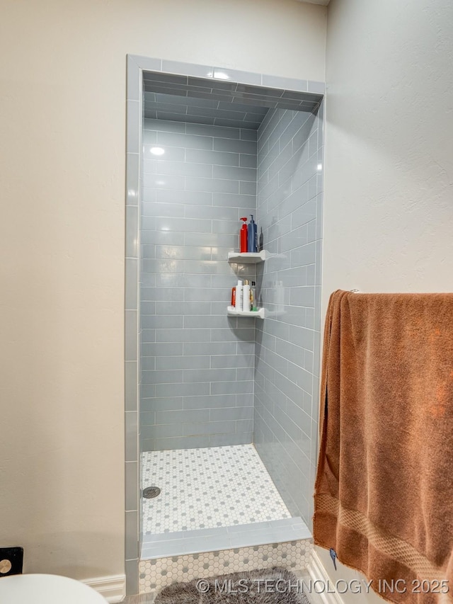 bathroom featuring a shower stall and toilet