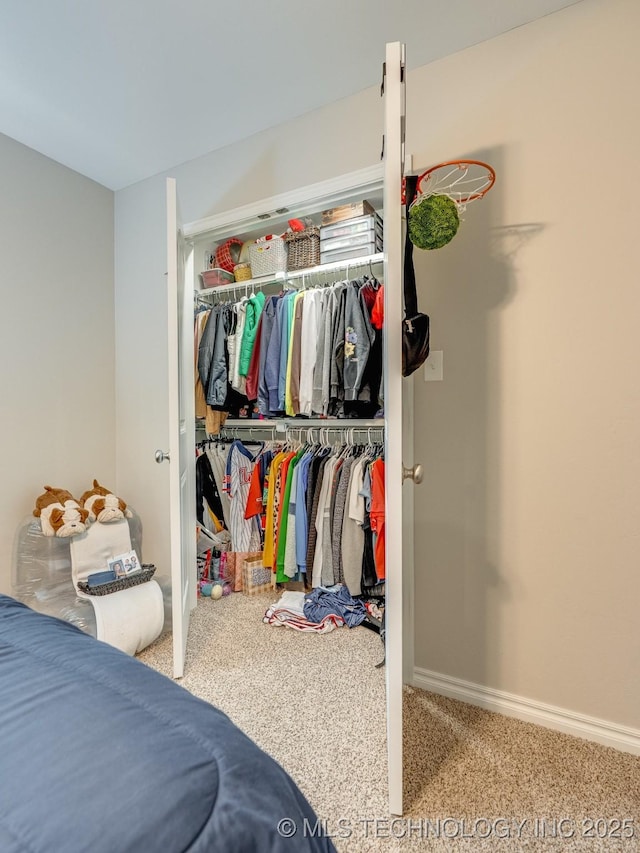 carpeted bedroom with a closet and baseboards