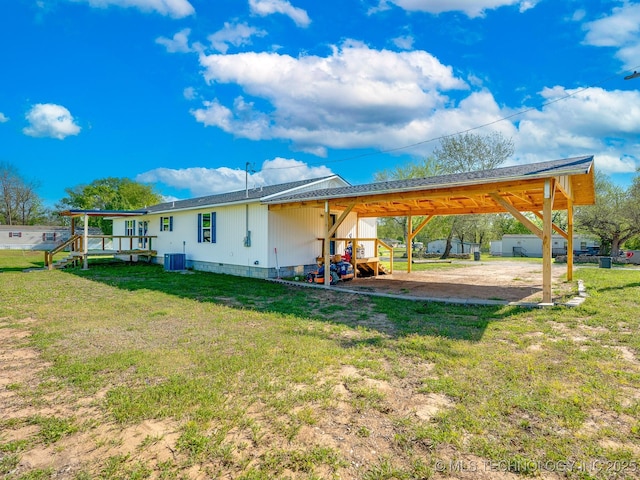 back of house with cooling unit, a lawn, and dirt driveway
