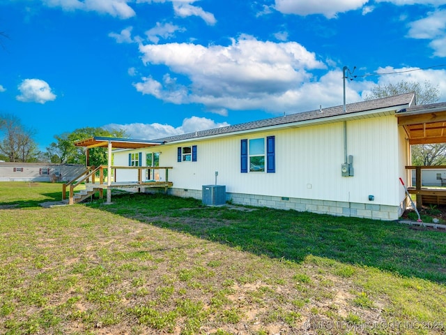 back of property featuring central air condition unit, crawl space, and a lawn