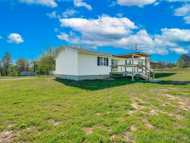 rear view of property with crawl space, a wooden deck, and a lawn