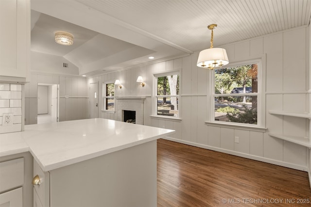 3004 E 49th St, Tulsa, OK 74105 - kitchen featuring a decorative wall, a peninsula, wood finished floors, and a fireplace