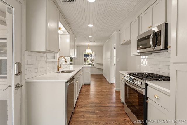 3004 E 49th St, Tulsa, OK 74105 - kitchen with stainless steel appliances, dark wood-style floors, light countertops, and a sink