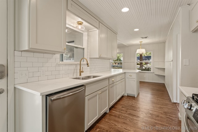 3004 E 49th St, Tulsa, OK 74105 - kitchen with dark wood finished floors, tasteful backsplash, light countertops, a sink, and stainless steel appliances