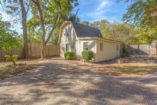 3004 E 49th St, Tulsa, OK 74105 - view of side of home with a shingled roof, an outdoor structure, fence, a gambrel roof, and driveway