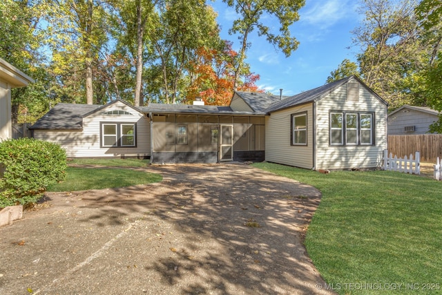 3004 E 49th St, Tulsa, OK 74105 - view of front of house with a sunroom, driveway, fence, and a front lawn