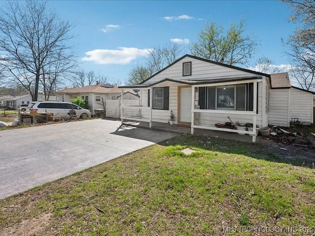 view of front of house featuring concrete driveway and a front lawn