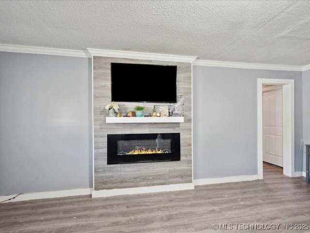 unfurnished living room with baseboards, wood finished floors, and a large fireplace