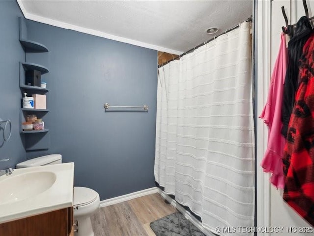 bathroom with wood finished floors, vanity, a shower with curtain, baseboards, and toilet