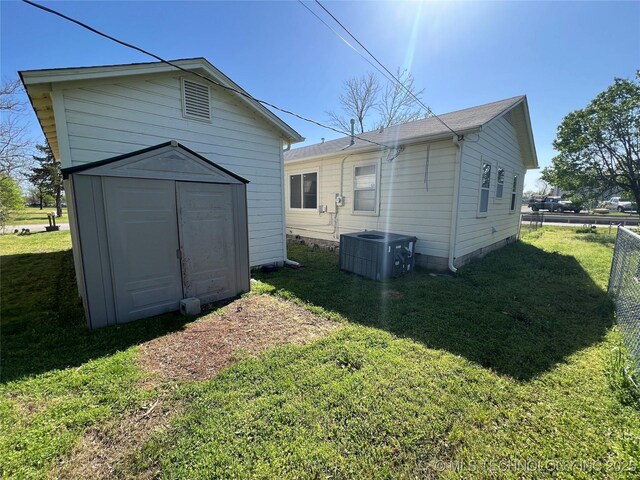 319 S Main St, Owasso, OK 74055 - rear view of house with an outdoor structure, fence, a lawn, and a storage unit