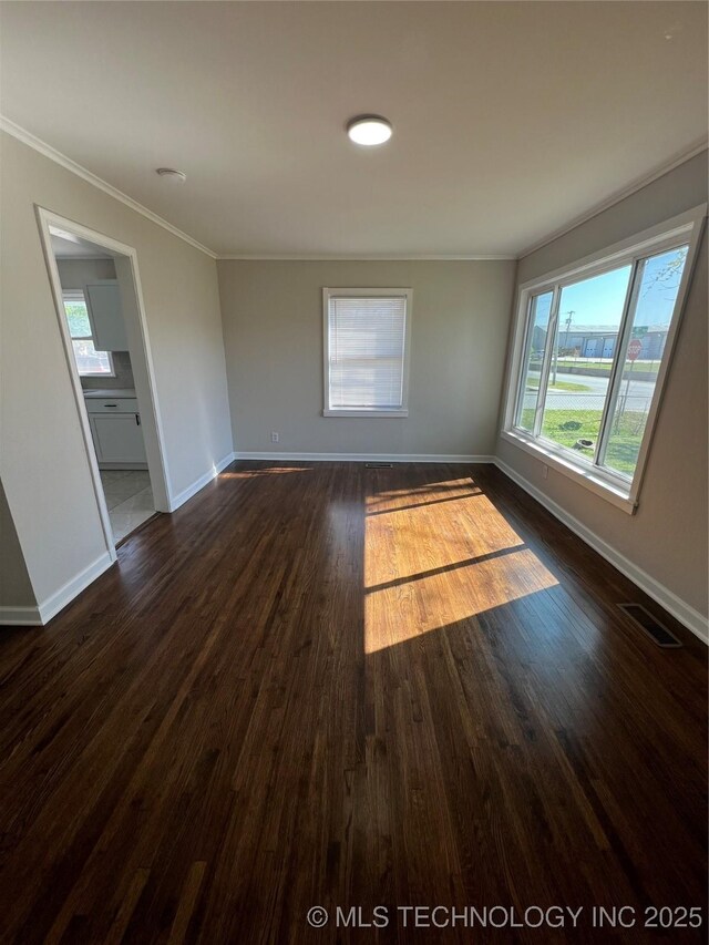 319 S Main St, Owasso, OK 74055 - unfurnished room with dark wood-type flooring, baseboards, ornamental molding, and visible vents