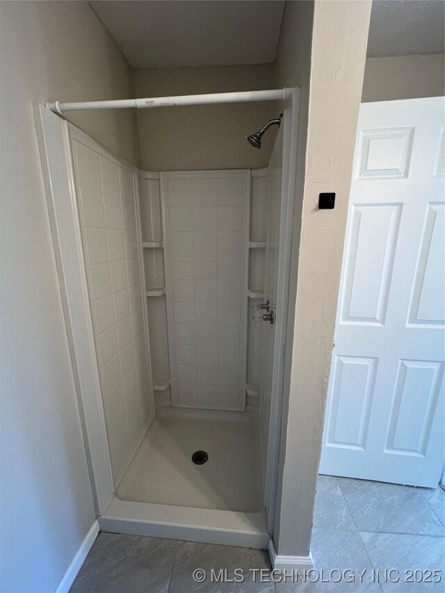 319 S Main St, Owasso, OK 74055 - full bathroom with a tile shower, baseboards, and tile patterned flooring