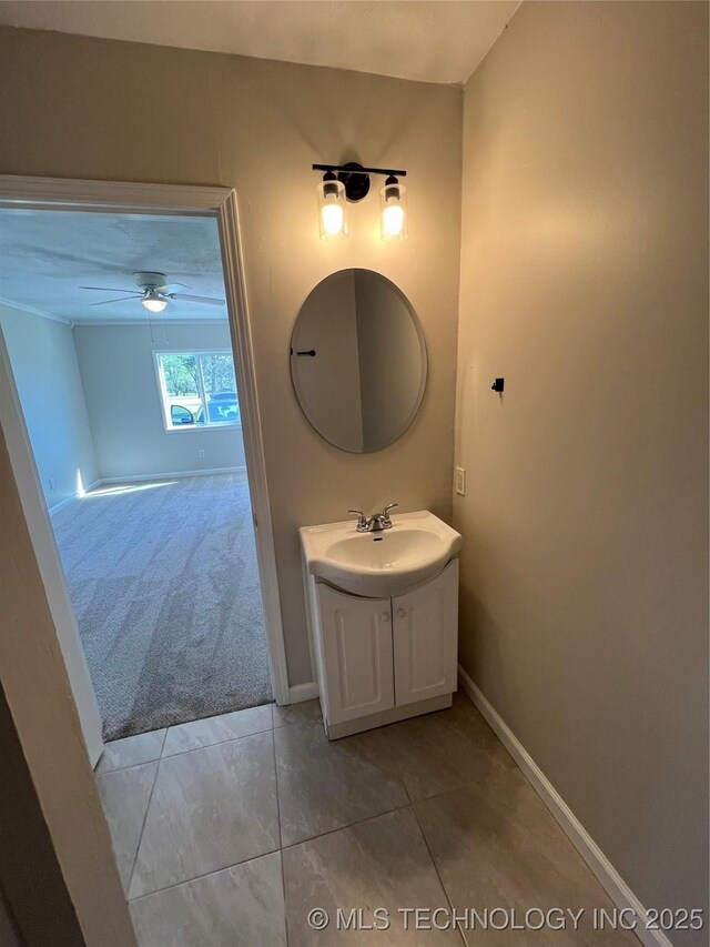 319 S Main St, Owasso, OK 74055 - bathroom with tile patterned floors, vanity, baseboards, and a ceiling fan