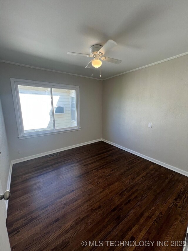 319 S Main St, Owasso, OK 74055 - empty room with visible vents, baseboards, ceiling fan, dark wood finished floors, and crown molding