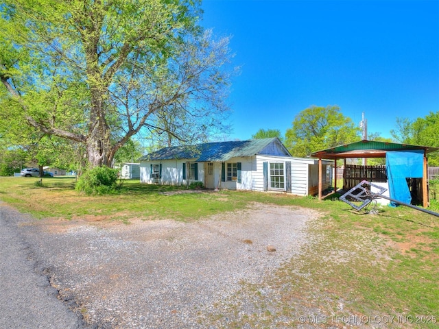 ranch-style house with metal roof and a front lawn